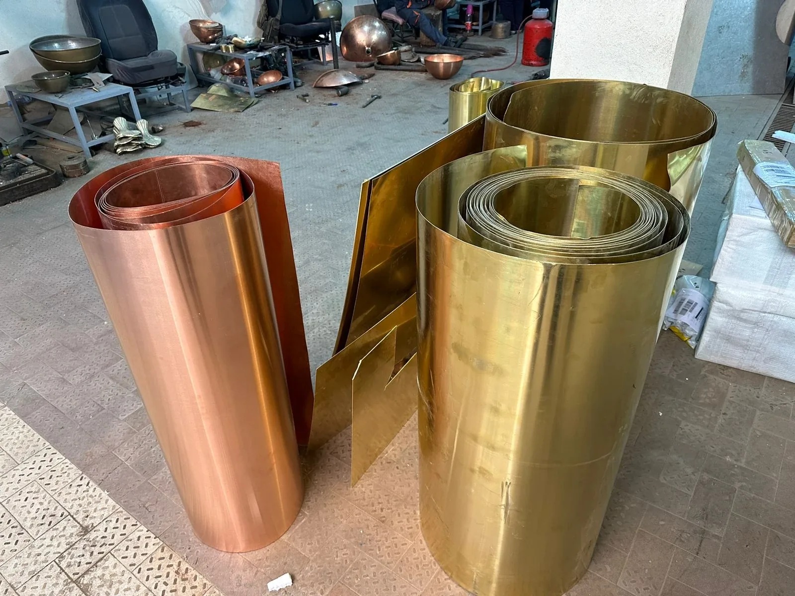 Brass sculptural objects beside a curved sofa